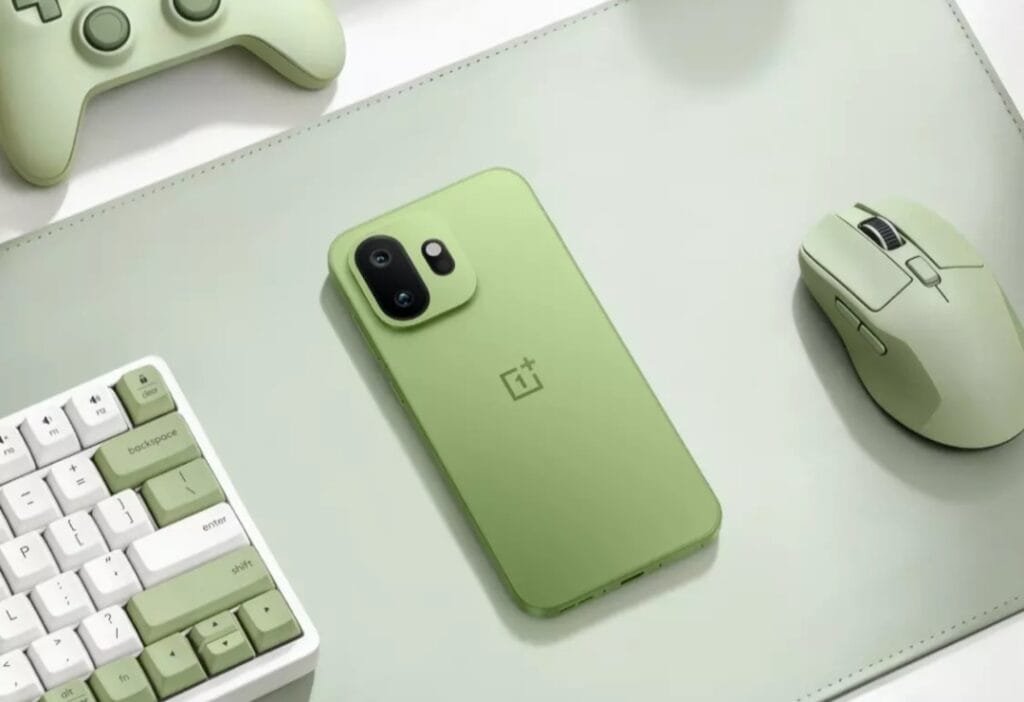 OnePlus 15T in Relaxed Matcha green color displayed with matching green gaming accessories including a keyboard, mouse, and controller on a light green desk mat – showcasing the phone’s sleek design and coordinated aesthetic.