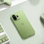 OnePlus 15T in Relaxed Matcha green color displayed with matching green gaming accessories including a keyboard, mouse, and controller on a light green desk mat – showcasing the phone’s sleek design and coordinated aesthetic.