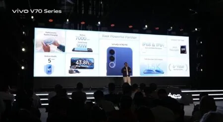 vivo V70 Series launch stage presentation showing V70 FE features like 7000mAh battery, 90W charging, Dimensity 7360 Turbo, IP68/69 resistance, and 6-year updates; audience in foreground.
