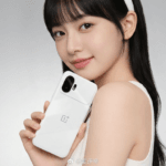 OnePlus 15T First Look Leaked, Poster Reveals Features and Specifications 2 A promotional photo of a young woman with black hair holding a white OnePlus 15T. The phone features a minimalist "Healing White Chocolate" back with a distinct, rectangular black camera island in the top-left corner, housing two vertically aligned camera lenses and a small LED flash.