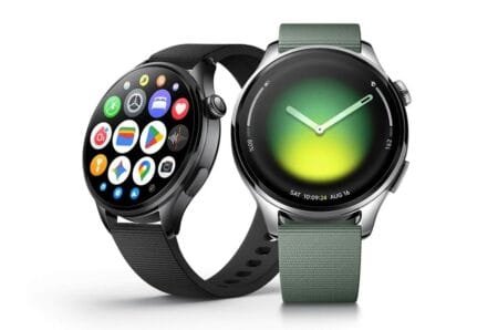 Xiaomi Watch 5 Priced at €299.99 in Europe Two smartwatches, the Xiaomi Watch 5, are displayed side-by-side. One features a black finish with a vibrant app grid on the screen, while the other has a silver stainless steel case with a green analog face and a juniper green fabric strap.