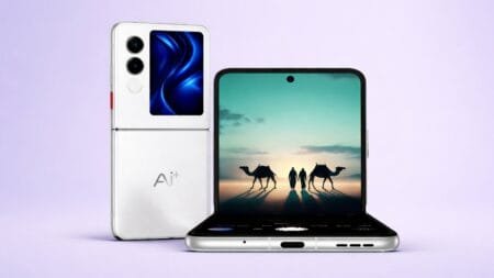 AI Plus Nova Flip Debuts in India with Foldable Display, Dimensity 7300X AI+ Nova Flip foldable smartphone displayed against a soft purple background. Shown in two positions: closed on the left, featuring a vertical camera module, small outer display with blue abstract wallpaper, and "AI+" branding; open on the right, revealing a large inner screen showing a desert landscape with two people and camels at sunset. The device has a sleek silver finish with visible ports and buttons on the bottom edge.