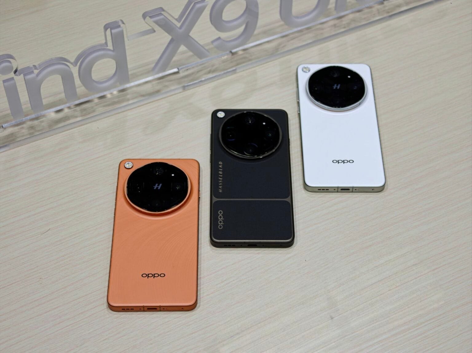 Oppo Find X9 Ultra smartphones displayed in three color variants: Orange, Black and White