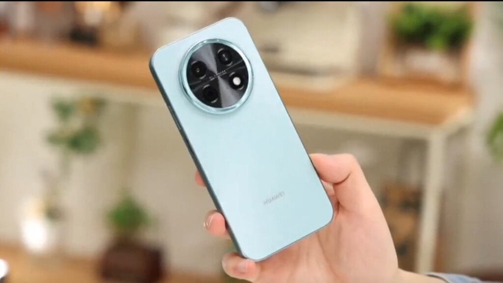 New Huawei Phones Certified, Possible Enjoy 90 Series Additions Light blue Huawei Enjoy 90 Plus smartphone held in hand, showcasing its circular camera module with four lenses and Huawei logo on the back panel
