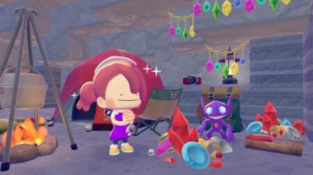 Screenshot from Pokémon Pokopia showing a female trainer character smiling beside Sableye, surrounded by colorful gemstones, treasure, and camping gear with hanging crystal decorations