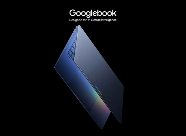 Sleek Googlebook laptop shown open at an angle against a black background; text reads “Googlebook — Designed for Gemini Intelligence”; deep blue gradient finish, subtle rainbow accent light along the hinge.