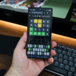 Hand holding smartphone showing Wordle game on NY Times website; guesses: CRANE (A,N yellow), SLATE (A,T yellow), POISE (P green), final correct answer PARKS (all green tiles). On-screen keyboard highlights used and correct letters.