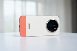 Honor X80 Pro Max rear view in two‑tone white and coral finish, large circular camera module, vertical Honor logo, premium design on white surface.