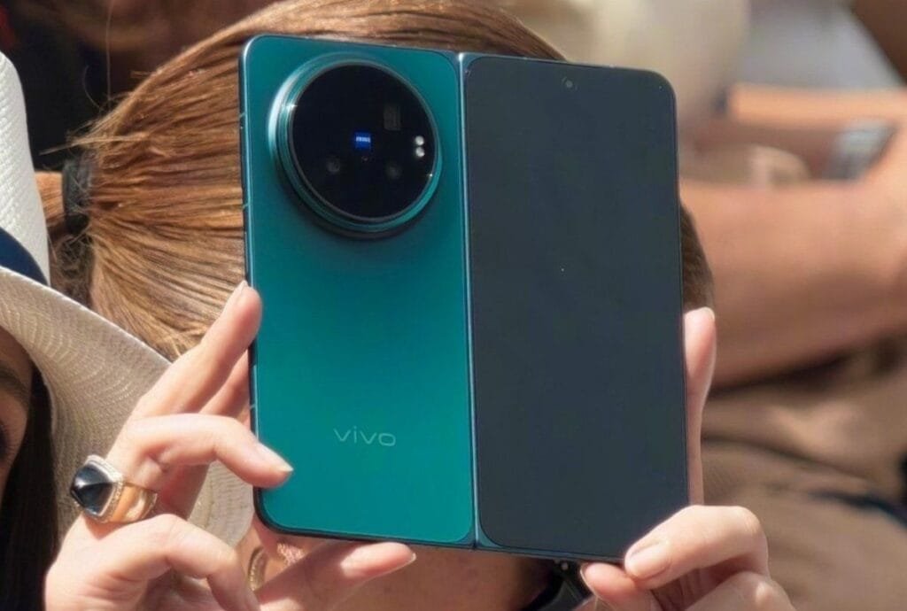 Zhu Zhu Uses Vivo X Fold 6: First Look, Design and Key Details 2 Detailed view of the Vivo X Fold 6 in hand, showcasing the big camera ring with multiple lenses, blue accent light, and smooth frame design.
