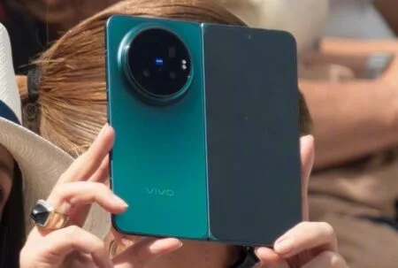 Detailed view of the Vivo X Fold 6 in hand, showcasing the big camera ring with multiple lenses, blue accent light, and smooth frame design.