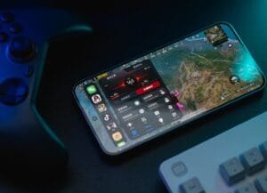 Redmi K90 Ultra smartphone displaying a game interface with 165 FPS performance, game tools menu, and active cooling status, placed beside a game controller and Xiaomi keyboard to highlight its gaming features.
