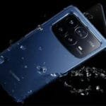 Xiaomi 17 Fold or Xiaomi Mix Fold 5 foldable smartphone in blue finish with Leica camera module, surrounded by water droplets against a black background