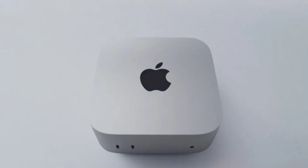 Apple Mac Mini with M6 chip, compact silver desktop device with Apple logo on top and front-facing ports