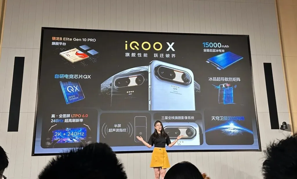 iQOO X concept phone specs overview on stage screen, highlighting Snapdragon 8 Elite Gen 10 Pro, QX gaming chip, 15,000mAh battery, full-screen display, ultrasonic fingerprint, triple cameras, and satellite connectivity.