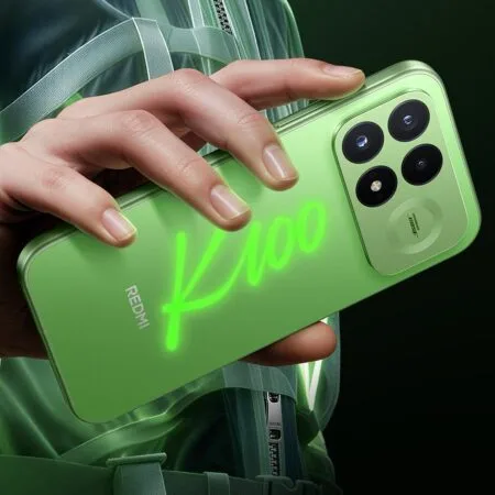 A close-up shot of a hand holding the Redmi K100 Pro, demonstrating its glow-in-the-dark feature. A bright, glowing green "K100" logo is hand-drawn across the translucent green rear panel, which also features a square camera island with four circular cutouts and a "Sound by Bose" branding badge.