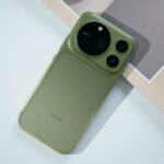 Honor Magic 9 Pro Max in Moss Green shown from the back. Large circular camera module with ARRI branding and two smaller lenses. Split finish design with textured lower panel and HONOR logo centered. White background with partial paper print. Official product shot.
