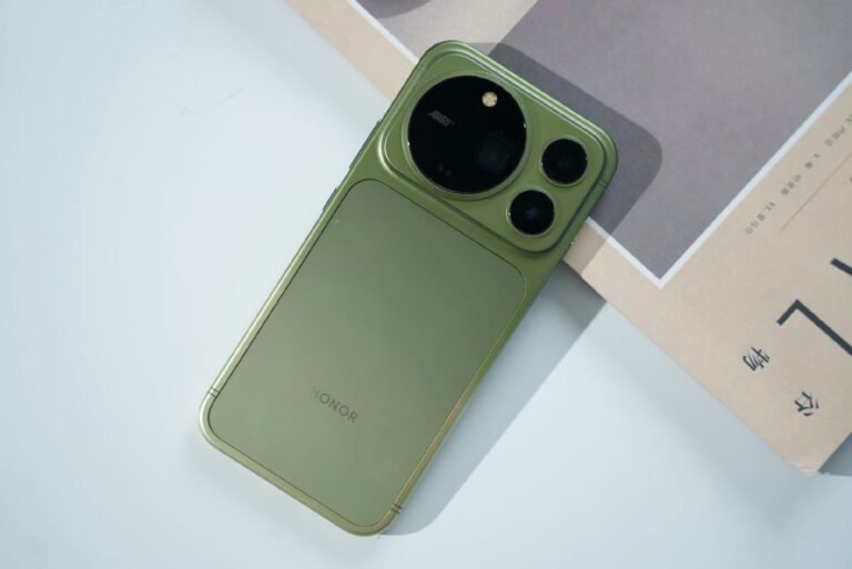 Honor Magic 9 Pro Max in Moss Green shown from the back. Large circular camera module with ARRI branding and two smaller lenses. Split finish design with textured lower panel and HONOR logo centered. White background with partial paper print. Official product shot.