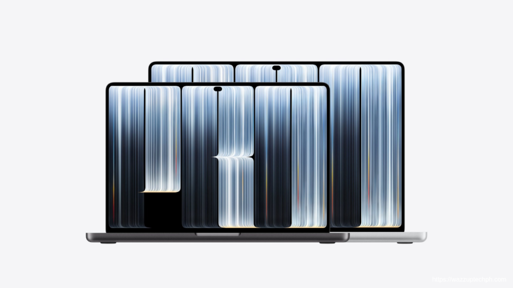 Two Apple MacBook Pro 2026 units in space‑gray and silver finishes, showing their PROLED XRD displays with flowing blue‑white line‑art graphics, set against a plain light‑white background.
